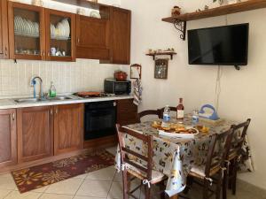 eine Küche mit einem Tisch mit Stühlen und einem Waschbecken in der Unterkunft Cottage Sara in Castellana Grotte