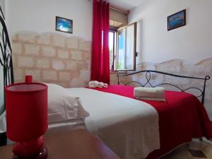 a bedroom with a bed with a red blanket at Casa Relax Acqua Marina in Favignana