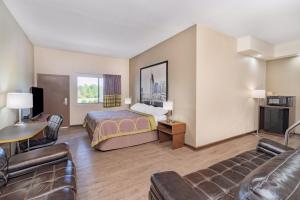 a hotel room with a bed and a couch at Super 8 by Wyndham Columbia in Columbia