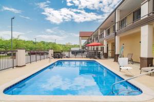 a pool at a hotel with chairs and a patio at Super 8 by Wyndham Columbia in Columbia