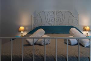a bedroom with a bed with a headboard and two lamps at Phos apartment in Heraklio Town
