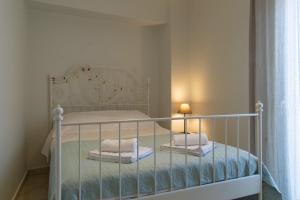Un dormitorio con una cama blanca con toallas. en Phos apartment, en Heraclión