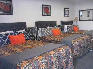 un grupo de 3 camas en una habitación en Western Motel, en Lovell