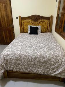 Una cama con una almohada negra encima. en Appartment in Keur Massar, en Keur Massar