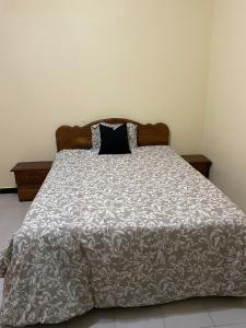 Una cama con una almohada negra encima. en Appartment in Keur Massar, en Keur Massar