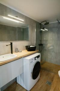 a bathroom with a washing machine and a sink at Stamatina's Luxury Apartments (Superior Suite) in Alexandroupoli