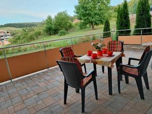 a table and chairs on a balcony with a view at Slnečné apartmány in Podhájska