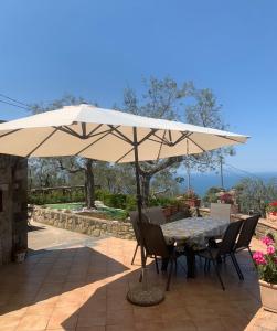 een tafel en stoelen onder een parasol op een patio bij A Sorrento in Sorrento