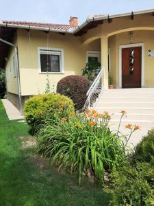 una casa con escaleras y flores en el patio en Villa Csilla elegant house, en Érd
