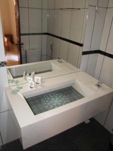 a bathroom with a bath tub with a sink at Hotel Fazenda Arara Azul in Carolina