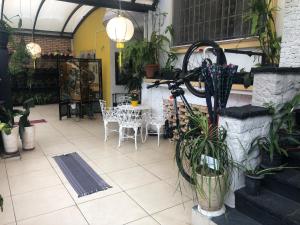 un patio con mesa, sillas y plantas en Hostel Ipê en São Paulo