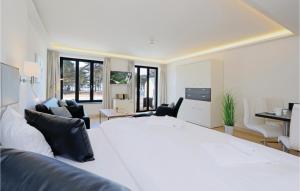 a white bedroom with a large white bed and chairs at Baltic in Binz