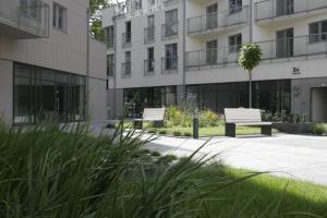 dwa ławki w parku przed budynkiem w obiekcie Apartament Neptun w Olsztynie