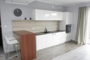 a kitchen with white cabinets and a counter top at Apartament Neptun in Olsztyn
