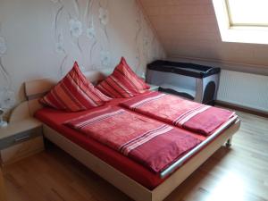 a bedroom with a bed with red sheets and a tv at Ferienwohnung Knaub in Bad Wildungen