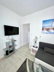 een woonkamer met een bank en een flatscreen-tv bij Apartman LUNA Split Modern SEA VIEW Apartment in Split