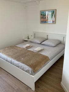 Bett in einem weißen Raum mit durchschnittlicher statistischer Anzeige in der Unterkunft Maison indépendante, domaine VICHY LA TOUR in Abrest
