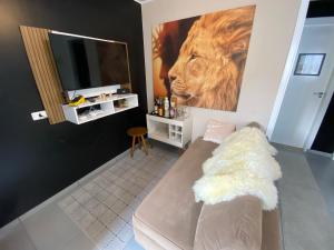 een woonkamer met een leeuwenverf aan de muur bij Casa Aconchegante próximo ao Capivari in Campos do Jordão