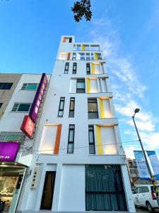 un edificio blanco con ventanas coloridas y luz de la calle en House Apartment, en Magong