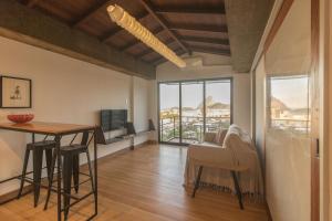 a living room with a dining room table and a television at Casa Do Gato Cinzento in Rio de Janeiro