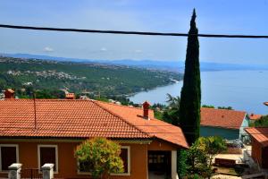 a house with orange roofs and a view of the water at Apartments Opatija Sea View in Opatija
