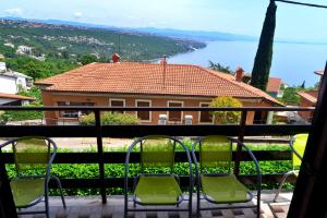 a balcony with chairs and a view of a house at Apartments Opatija Sea View in Opatija