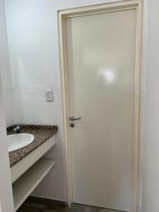 a bathroom with a white door and a sink at Cba Rent in Cordoba
