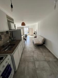 uma cozinha com armários brancos e uma sala de estar em Cba Rent em Córdoba