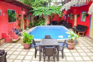 a patio with a table and chairs and a pool at Arrecife Montañita Hostal in Montañita