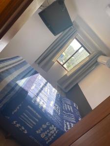 1 dormitorio con 1 cama con ventana y colcha en Wall Street Flat - Centro, en Caxias do Sul