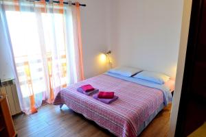 a bedroom with a bed with two red towels on it at Apartments Opatija Sea View in Opatija +30 photos