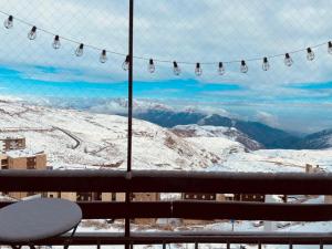 a view of the snow covered mountains from a window at La Parva Dpto in Farellones