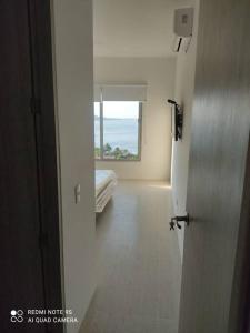 a door leading to a room with a bed and a window at Magnifico apartamento con vista y salida al mar in Santa Marta