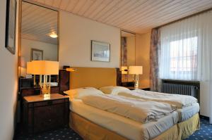 een slaapkamer met 2 bedden en een grote spiegel bij Hotel Zum Bäcker in Udenhain