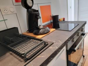 eine Küchentheke mit Kaffeemaschine und Tastatur in der Unterkunft LA GRANV'ILLAISE in Granville