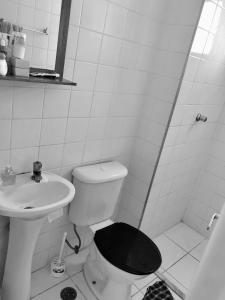 a white bathroom with a toilet and a sink at Apartamento bem Localizado in Sao Paulo