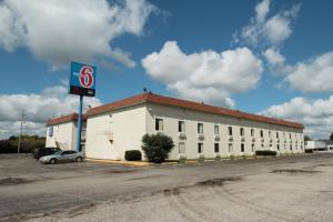 un gran edificio blanco con un cartel delante en Motel 6-Toledo, OH en Maumee