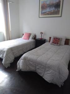 two beds sitting next to each other in a bedroom at hostal mancora monjitas 755 in Santiago