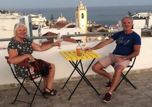 a man and woman sitting at a table with glasses of wine at Vila Algarvia Boutique & Suites in Albufeira