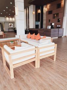 a living room with two white couches and orange pillows at Kasa Bae in Tagaytay