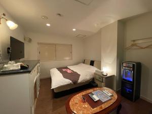 Habitación pequeña con cama pequeña y mesa en HOTEL マナティ, en Akashi