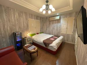 Habitación pequeña con cama y mesa pequeña en HOTEL マナティ, en Akashi