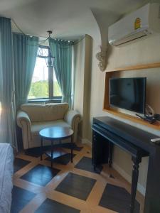 a living room with a couch and a flat screen tv at Espana Resort Pattaya Jomtien in Jomtien Beach