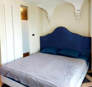 a bed with a blue headboard in a bedroom at Espana Resort Pattaya Jomtien in Jomtien Beach +6 photos