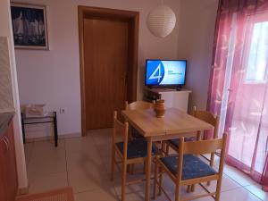 ein Esszimmer mit einem Tisch und einem TV in der Unterkunft Apartment Alice in Pakoštane
