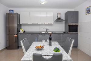 eine Küche mit einem Tisch und einer Obstschale darauf in der Unterkunft Apartments Mario in Brodarica