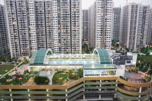 a large building with a pool in front of tall buildings at QMP - Vinhomes Ocean Park in Hanoi