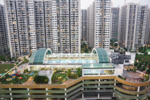 a large building with a pool in front of tall buildings at Vinhomes Ocean Park Gia Lam by QMP in Hanoi