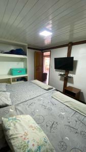 a bedroom with two beds and a flat screen tv at Condomínio Eco Resort Lençóis in Barreirinhas