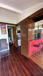 uma cozinha com um bar e cadeiras num piso de madeira em Condomínio Eco Resort Lençóis em Barreirinhas